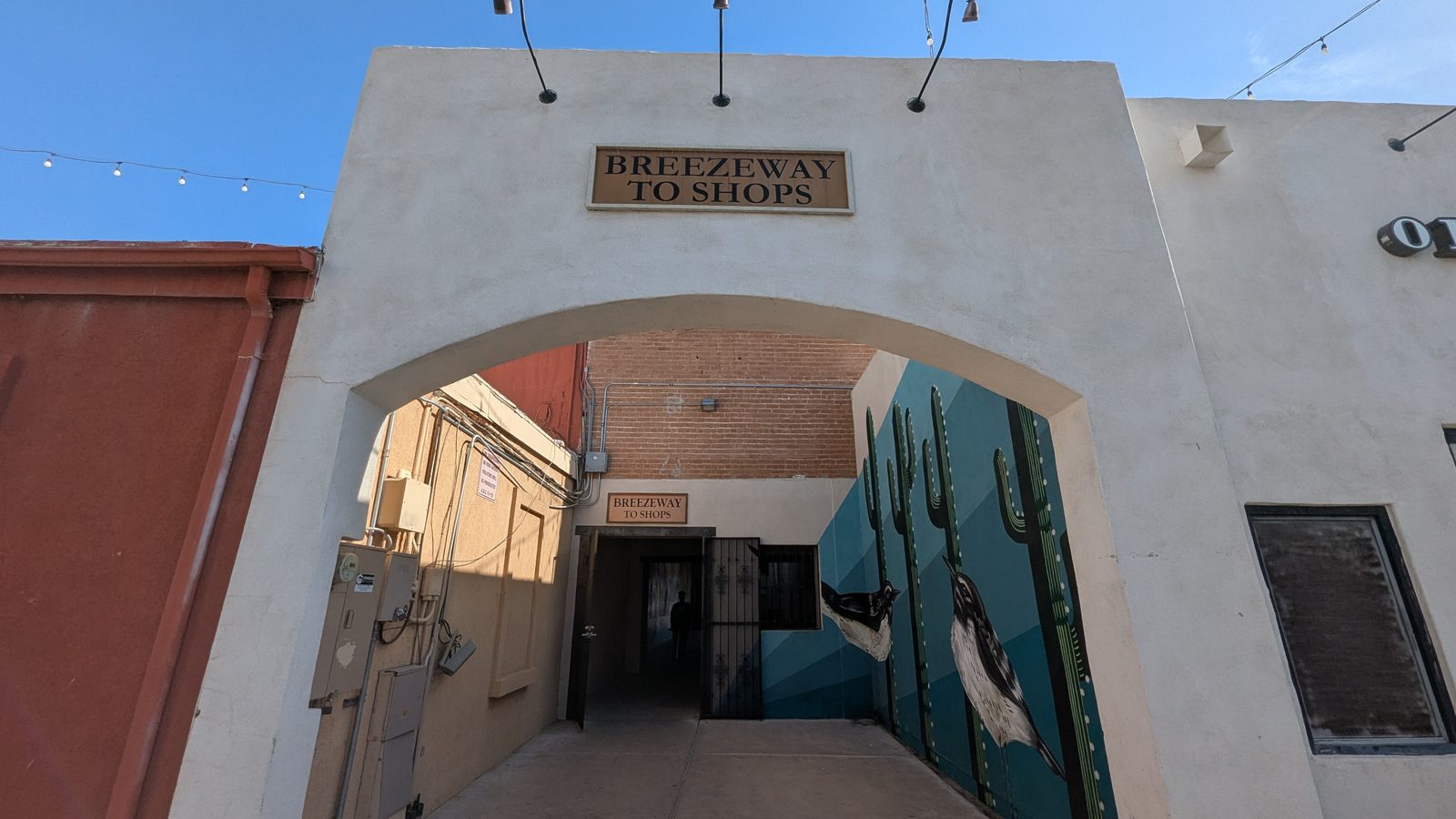 Close-up of the Breezeway to Shops archway with a roadrunner and cactus mural